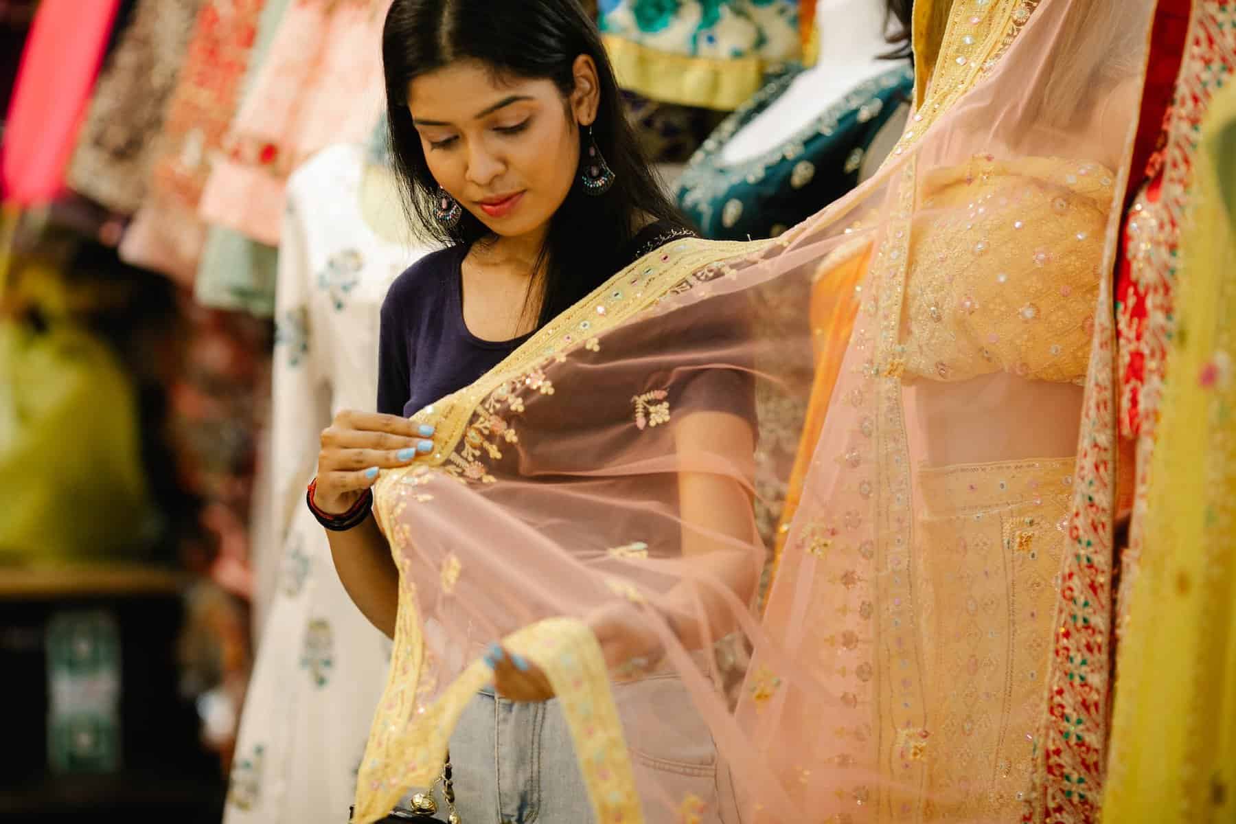 woman touching the yellow sari from the mannequin